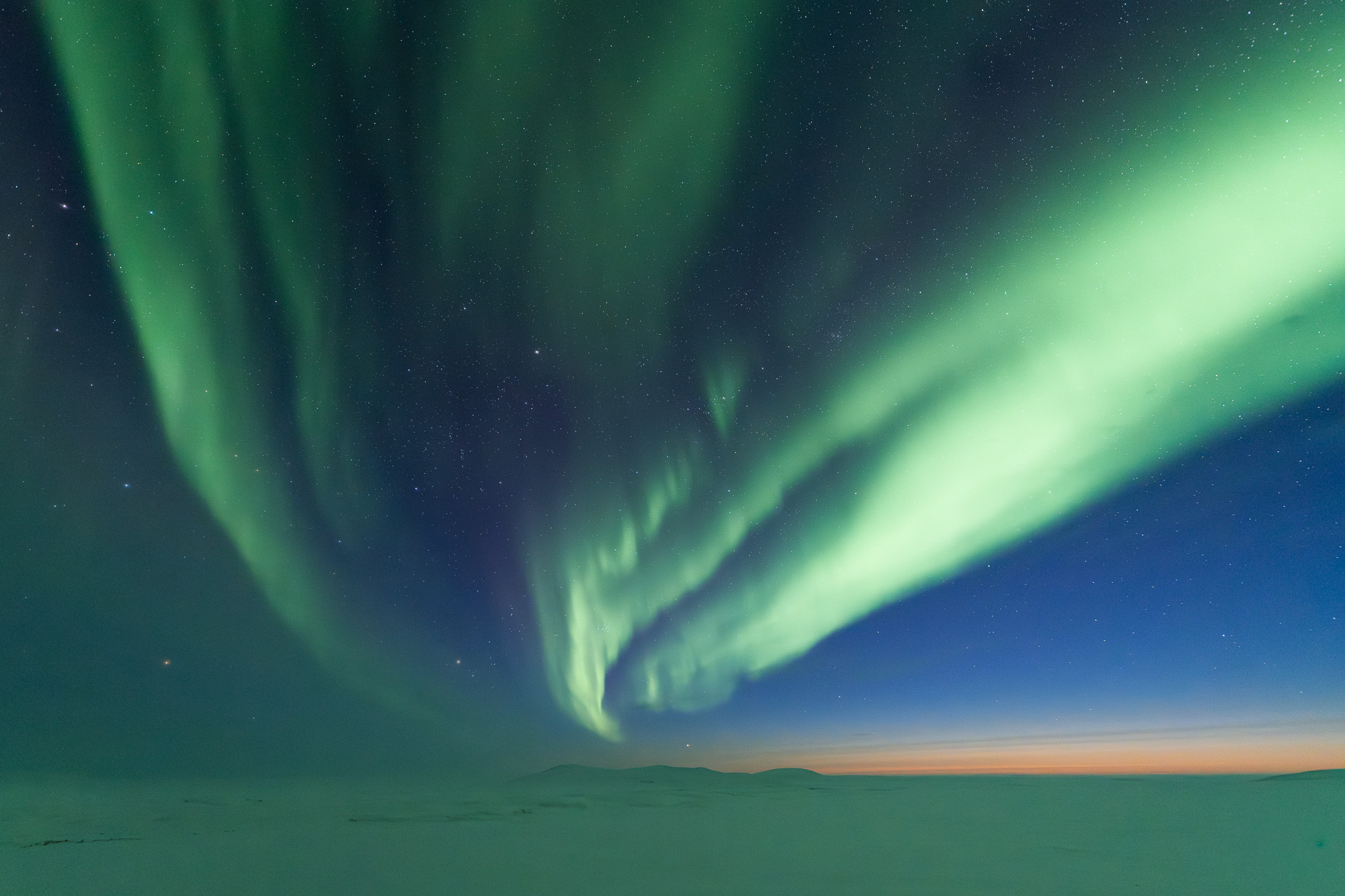 Aurora over tundra during twilight in Alaska